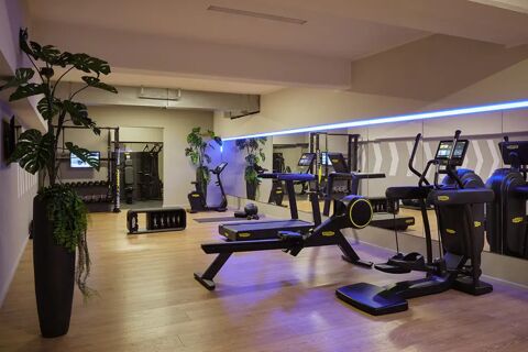 Modern ausgestatteter Fitnessraum im Leonardo Royal Hotel Mannheim mit Laufb&auml;ndern, Ruderger&auml;t, Hanteln und hellen Holzb&ouml;den.