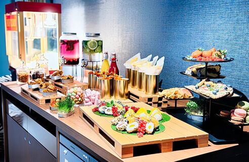 Buffet mit Obst, Snacks, Getr&auml;nken und S&uuml;&szlig;igkeiten im modernen Stil im NYX Hotel Mannheim angeboten.