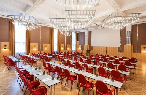 Gro&szlig;er, hell erleuchteter Konferenzraum im NYX Hotel Mannheim mit roten St&uuml;hlen und langen Tischen f&uuml;r Veranstaltungen und Tagungen.