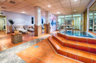 Innenansicht des Wellnessbereichs mit Whirlpool, Liegen und entspannter Atmosph&auml;re im Leonardo Hotel Mannheim-Ladenburg.