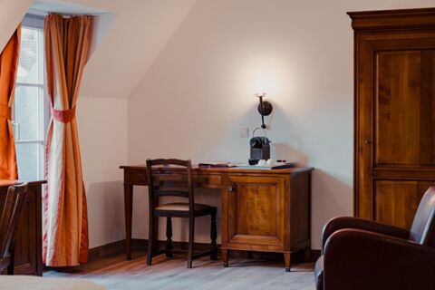 Wooden desk with coffee machine, two chairs, large wardrobe, and orange curtains near window in Gasthaus Backmulde - Hotel