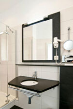 Kamar mandi modern dengan shower, cermin besar, dan pengering rambut di Gasthaus Backmulde - Hotel, ramah dan cerah.