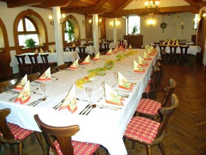 Dining room of Gasthof zur Sonne with long tables covered in white tablecloths and neatly arranged place settings