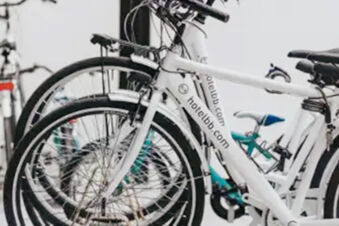 White bicycles with black tires and the text hotelbb.com lined up closely together at B&B Hotel Ferrara