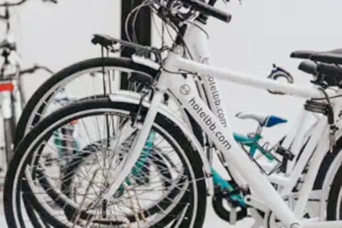 White bicycles with black tires and the text hotelbb.com lined up closely together at B&B Hotel Ferrara