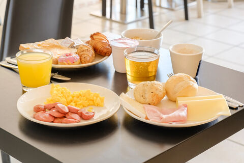 Scrambled eggs with sausage, bread rolls, ham, cheese, croissants, orange juice, apple juice, yogurt, and coffee at B&B Hotel Ferrara