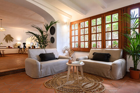 Two beige sofas with black pillows around a small round wooden table on a patterned rug at B&B HOTEL Ischia San Nicola