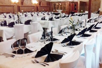 Sl&aacute;vnostne vyzdoben&aacute; jed&aacute;leň s bielymi obrusmi a čiernymi obr&uacute;skami v hoteli Gasthaus Zur Linde Diersburg na podujatia.