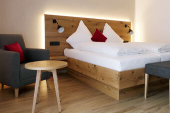 Moderne zariaden&aacute; izba v hoteli Gasthaus Zur Linde Diersburg s dreven&yacute;m n&aacute;bytkom, pohodln&yacute;mi posteľami a &scaron;t&yacute;lov&yacute;mi akcentmi.