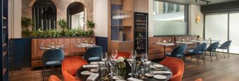 Dining area with round and rectangular tables set with glassware and plates at NH Collection Roma Centro