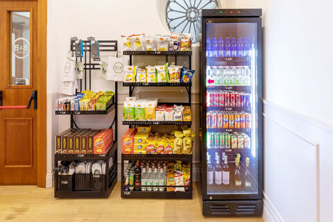Snack shelves with chips, cookies, bottled water, canned drinks, and wine in the B&B Hotel Roma Italia Viminale lobby