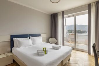 Double bed in a neutral-toned room at B&B Hotel Park Hotel Suisse Santa Margherita Ligure with balcony and sea view
