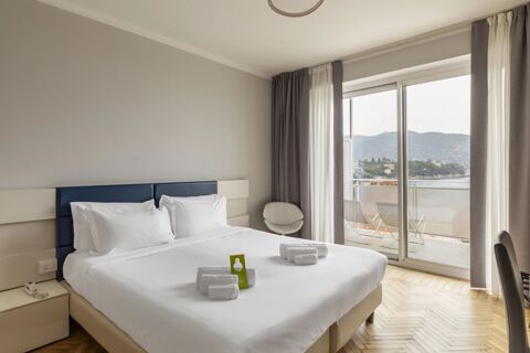 Double bed in a neutral-toned room at B&B Hotel Park Hotel Suisse Santa Margherita Ligure with balcony and sea view