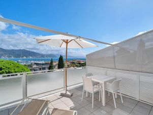 Terrace at B&B Hotel Park Hotel Suisse Santa Margherita Ligure with white chairs, table, umbrella, loungers, sea and mountain view