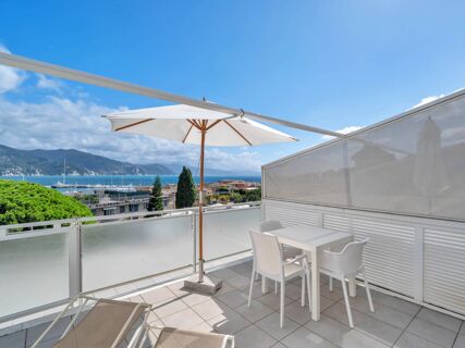 Terrace at B&B Hotel Park Hotel Suisse Santa Margherita Ligure with white chairs, table, umbrella, loungers, sea and mountain view