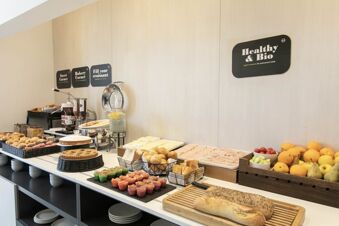 Breakfast buffet with pastries, muffins, breads, sliced meats, cheeses, fruits, and beverages at B&B Hotel Savona