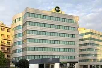 Modern building with long horizontal rows of windows and a green B&B Hotels sign on top, B&B Hotel Trapani Crystal