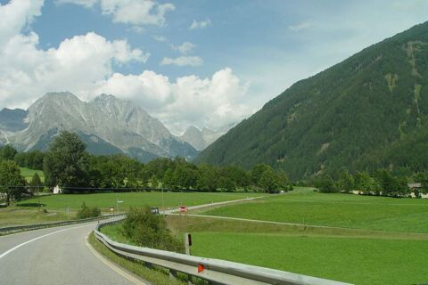 Paesaggio con prati verdi, strada tortuosa e montagne sullo sfondo presso il maso Innersieslhof, Villa Anna in Tirolo.