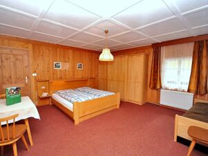 Hell eingerichtetes Holz-Zimmer mit Doppelbett, Kleiderschrank und Tisch im Bauernhof Villgrater am Ort f&uuml;r gem&uuml;tlichen Aufenthalt.
