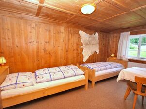 Gem&uuml;tliches Doppelzimmer mit Holzw&auml;nden, zwei Einzelbetten und Fenster mit Blick auf die Natur im Bauernhof Villgrater am Ort.