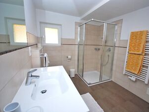 Modernes Badezimmer mit Duschkabine, Waschbecken und Handt&uuml;chern im Bauernhof Villgrater am Ort, sauber und hell gestaltet.