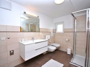 Moderne und helle Badezimmereinrichtung mit Dusche, WC, Bidet und gro&szlig;em Spiegel im Bauernhof Villgrater am Ort.