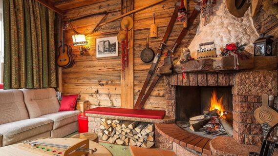 Salle de s&eacute;jour confortable avec des boiseries, un feu de chemin&eacute;e et des d&eacute;corations de style traditionnel &agrave; l'h&ocirc;tel Maria.