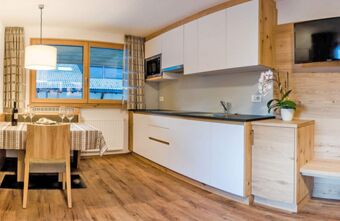 Kaasaegne k&ouml;&ouml;k koos s&ouml;&ouml;gilaua, puitp&otilde;randa ja televiisoriga Residence Flamingo suurtest akendest avaneva vaatega korteris.