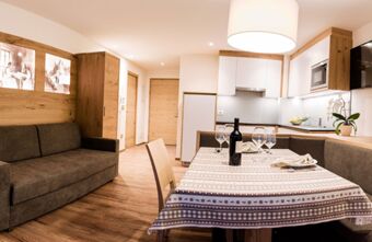 Modernses stiilis elutuba ja k&ouml;&ouml;k koos puidust aktsentide ja lauakomplektiga hubases atmosf&auml;&auml;ris Residence Flamingos.