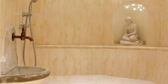 Elegantne vannitoa interj&ouml;&ouml;r Residence Flamingos koos marmorse seinapaneeli ja dekoratiivse kujuga ni&scaron;&scaron;is.