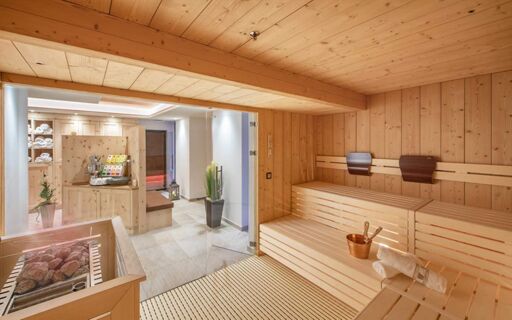 Saunaruimte met houten lambrisering en ontspanningsruimte in Hotel Theiner, ideaal voor wellness en ontspanning.