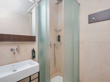 Bathroom interior at B&B Hotel Milano Central Station featuring a white sink with wall-mounted faucet and frosted glass shower doors