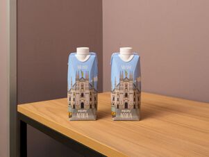 Two blue cartons of Milano branded Aqualy Acqua still water placed on a wooden table at B&B Hotel Milano Portello