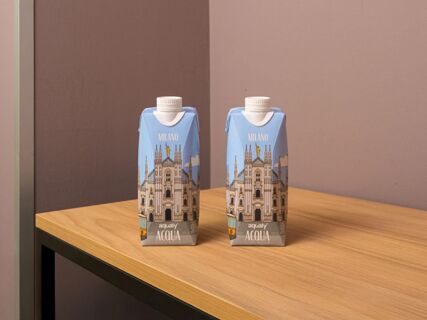 Two blue cartons of Milano branded Aqualy Acqua still water placed on a wooden table at B&B Hotel Milano Portello