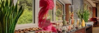 Breakfast buffet with pastries, fruits, juices, and various condiments displayed on a counter at NH Milano 2