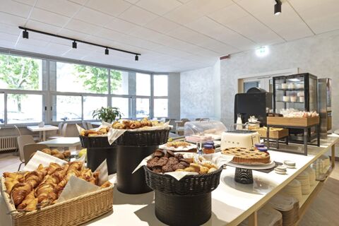 Breakfast buffet with pastries, muffins, cookies, and jams in a bright dining area at B&B Hotel Como City Center