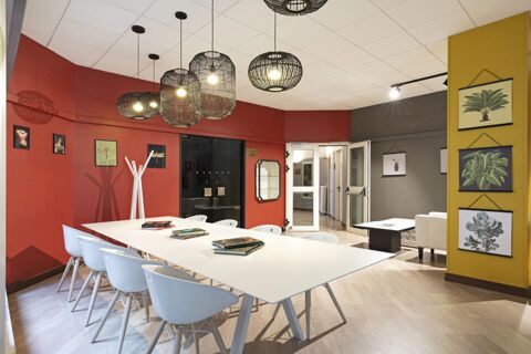 Modern conference room with white table, white chairs, hanging black light fixtures, and botanical prints at B&B Hotel Como City Center