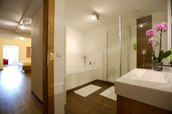 Moderne Badezimmeransicht mit Badewanne, Dusche und Waschbecken im Hotel-Restaurant-Cafe Friedenseiche, hell und sauber gestaltet.