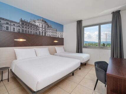 Double and single beds with white linen and lights mounted on a brown headboard with a large building image at B&B HotelPark Hotel Mondov&igrave;