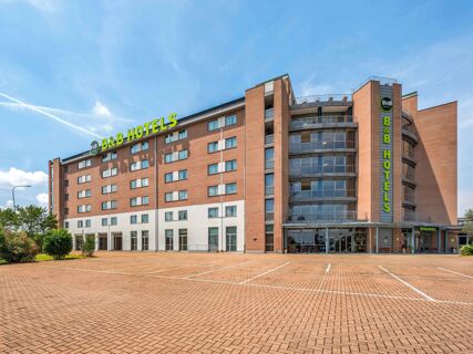 Brick and beige multi-story building with glass balconies and green B&B HotelPark Hotel Mondov&igrave; signs on top and side