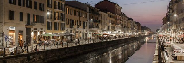 Nighttime view of a canal with riverside buildings and outdoor seating at restaurants near NH Collection NH Collection Milano Porta Nuova