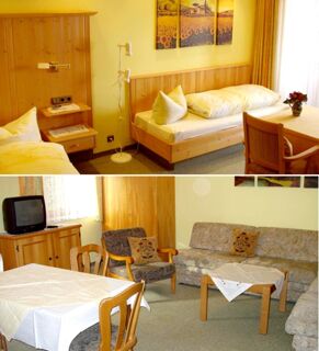 Gem&uuml;tliches Zimmer mit Einzelbetten, Sitzbereich und Esstisch in G&auml;stehaus zur F&auml;rbe Ferien-Appartements mit hellen Holzm&ouml;beln.
