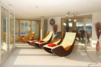 Heller Ruhebereich mit ergonomischen Liegest&uuml;hlen und roten Handt&uuml;chern im Panorama-Hotel Kaserer, ideal zum Entspannen.