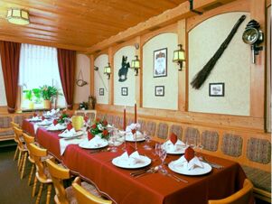 Dining room at Hotel Post Nordhalben with a long table set with red tablecloth, white napkins, and wooden chairs