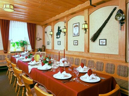 Dining room at Hotel Post Nordhalben with a long table set with red tablecloth, white napkins, and wooden chairs