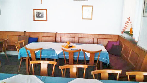 Gem&uuml;tlicher Essbereich mit Holzm&ouml;beln und blauen Tischdecken im Gasthof Waldbrunner Hof, passend f&uuml;r gemeinsame Mahlzeiten.