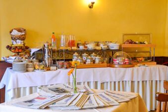 Breakfast buffet with breads, fruits, jars, and beverages on a table with white cloth at Posthotel Johannesberg