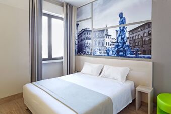 Bright hotel room with a double bed, white bedding, a window with curtains, and wall art of a Florence statue at B&B Hotel Firenze Novoli