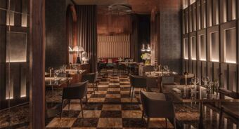 Dining area with marble checkered floor, modern dark chairs, wooden tables, soft lighting, and decorative bust at Anantara Palazzo Naiadi Rome Anantara Palazz