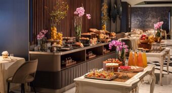 Buffet setup with pastries, fruit, juices, and floral decorations in a dining room at Anantara Palazzo Naiadi Rome Anantara Palazz